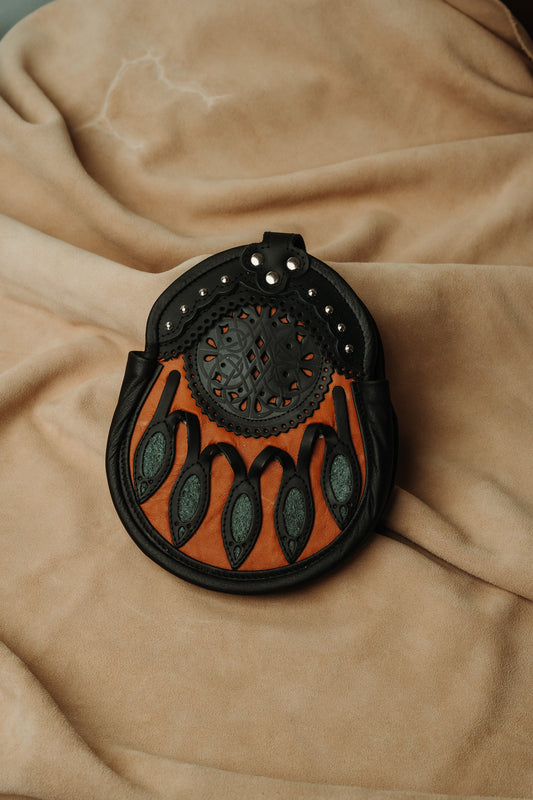 Sporran with red and green accents, celtic design cutouts and chrome stud word on the top