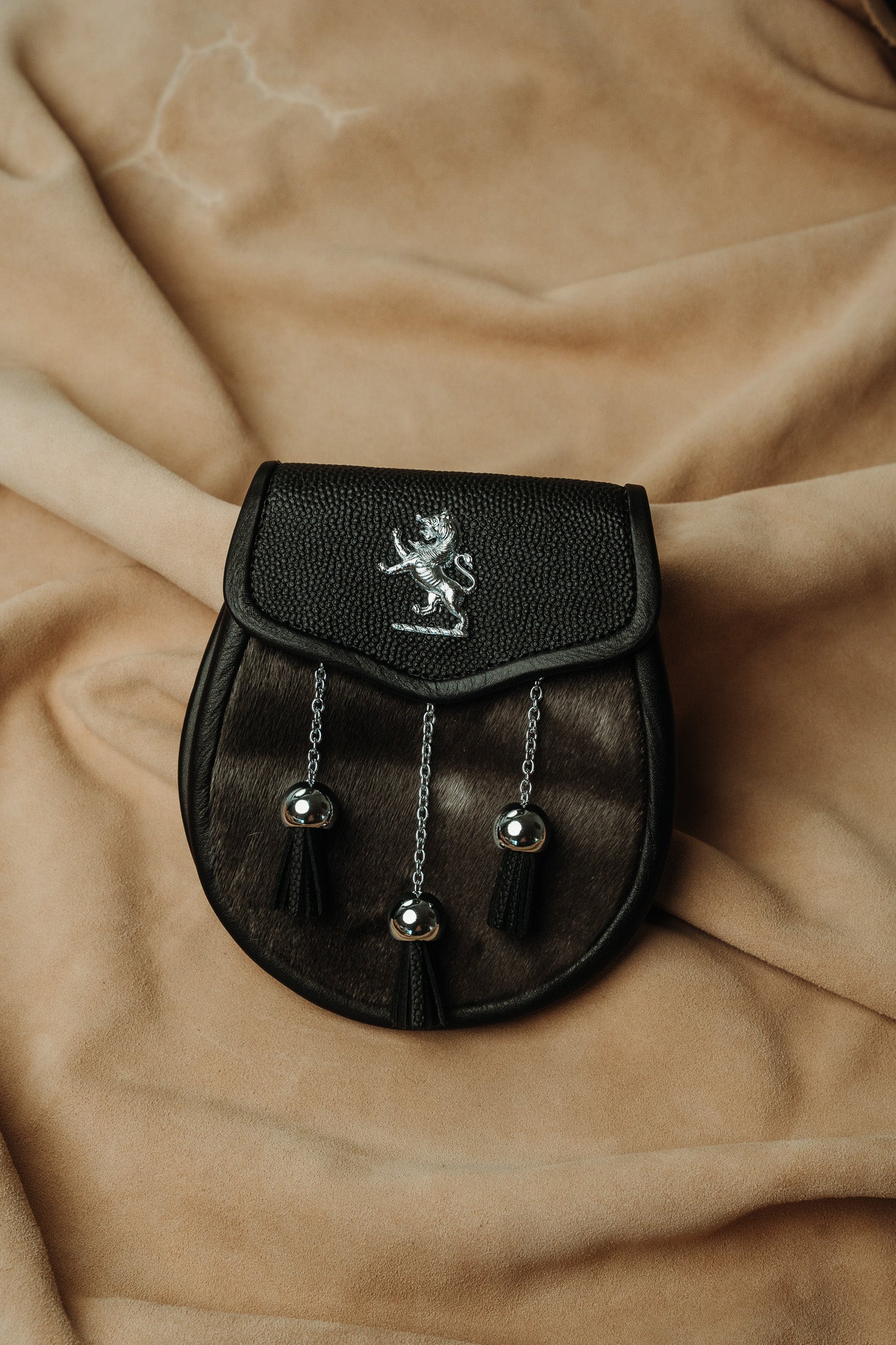 Sporran features luxurious black muskrat fur and a pebbled leather flap with lion badge and surrounding studwork.