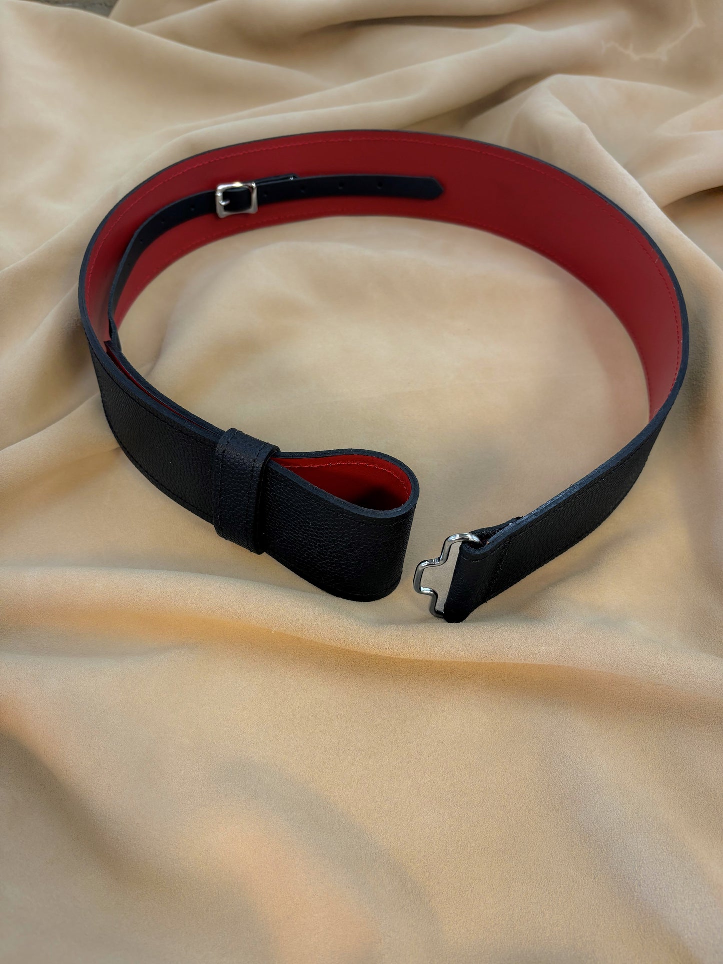 The outer leather is black and has a pebbled texture while the liner leather is smooth and red.