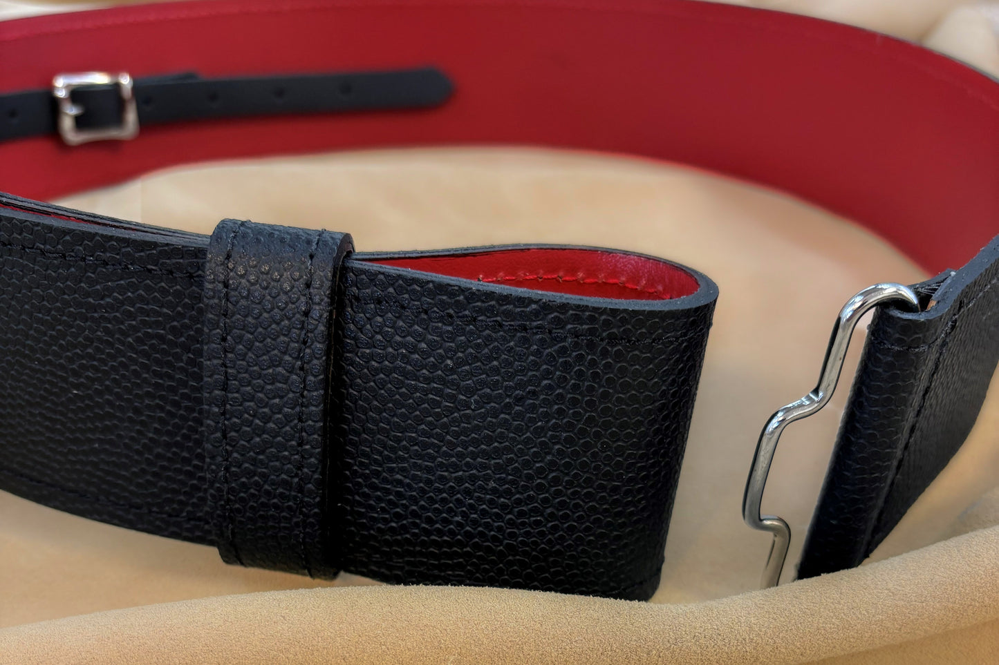 The outer leather is black and has a pebbled texture while the liner leather is smooth and red.