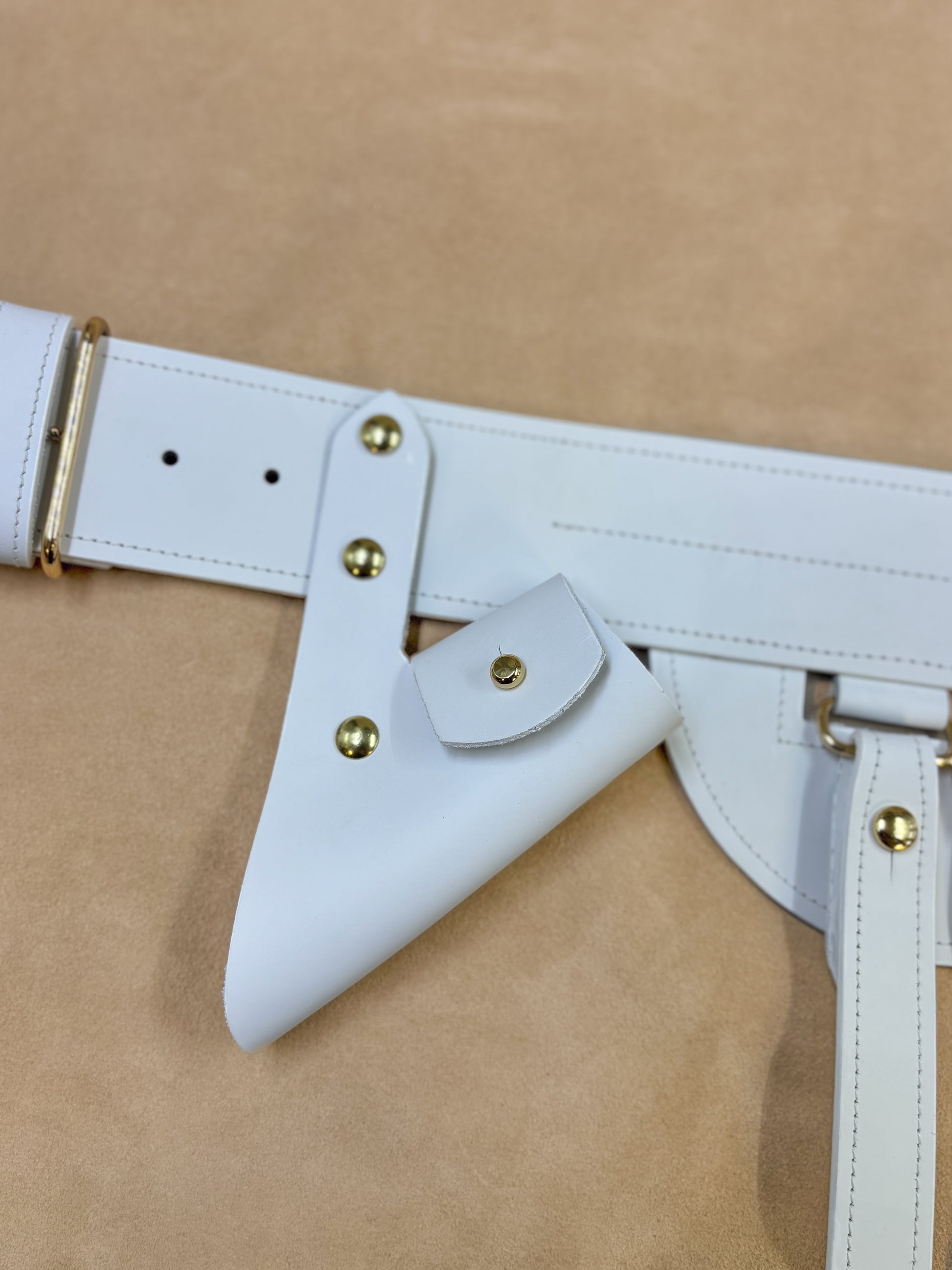 White leather sword frog with gilt hardware mounted on belt