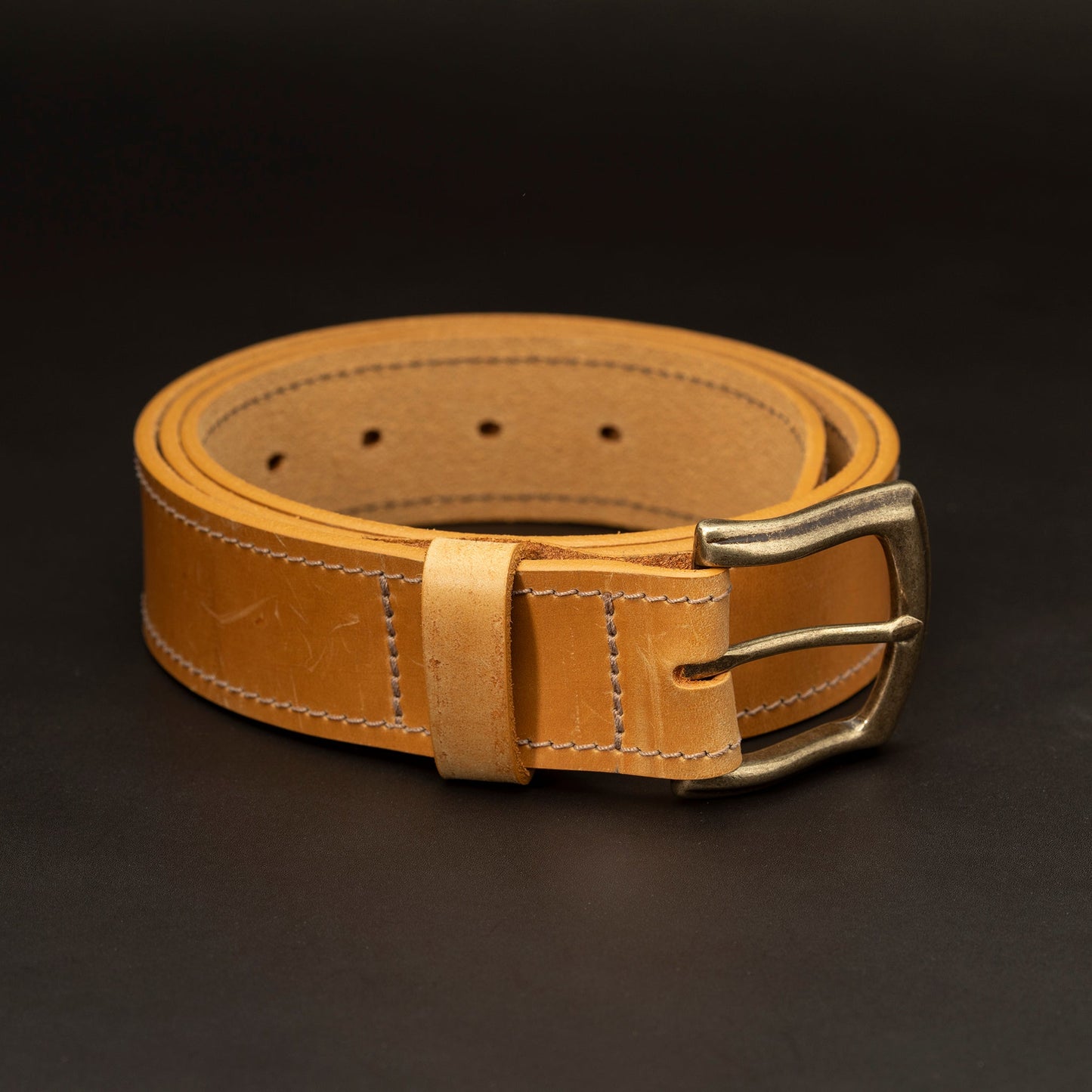 Russet leather belt with brass buckle and light stitching