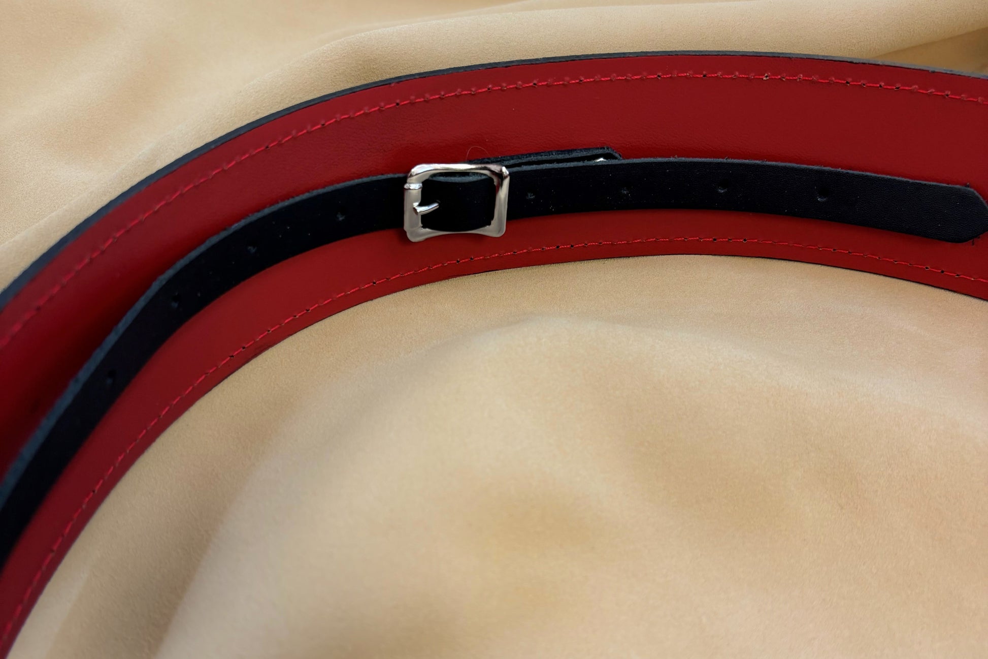 The outer leather is black and has a pebbled texture while the liner leather is smooth and red. 