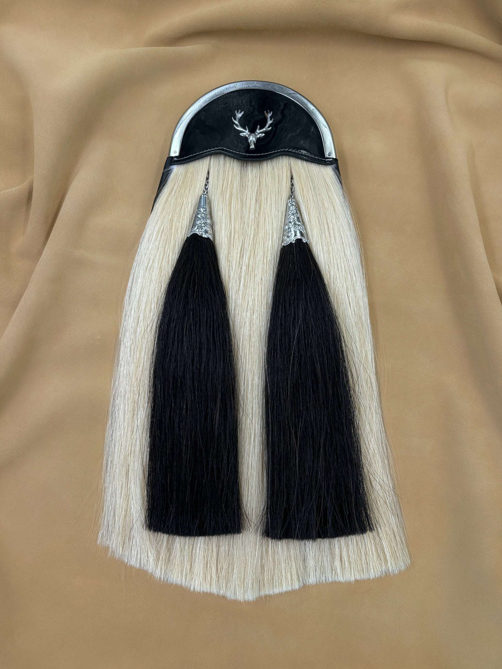 White horsehair sporran with black tassels and stag badge