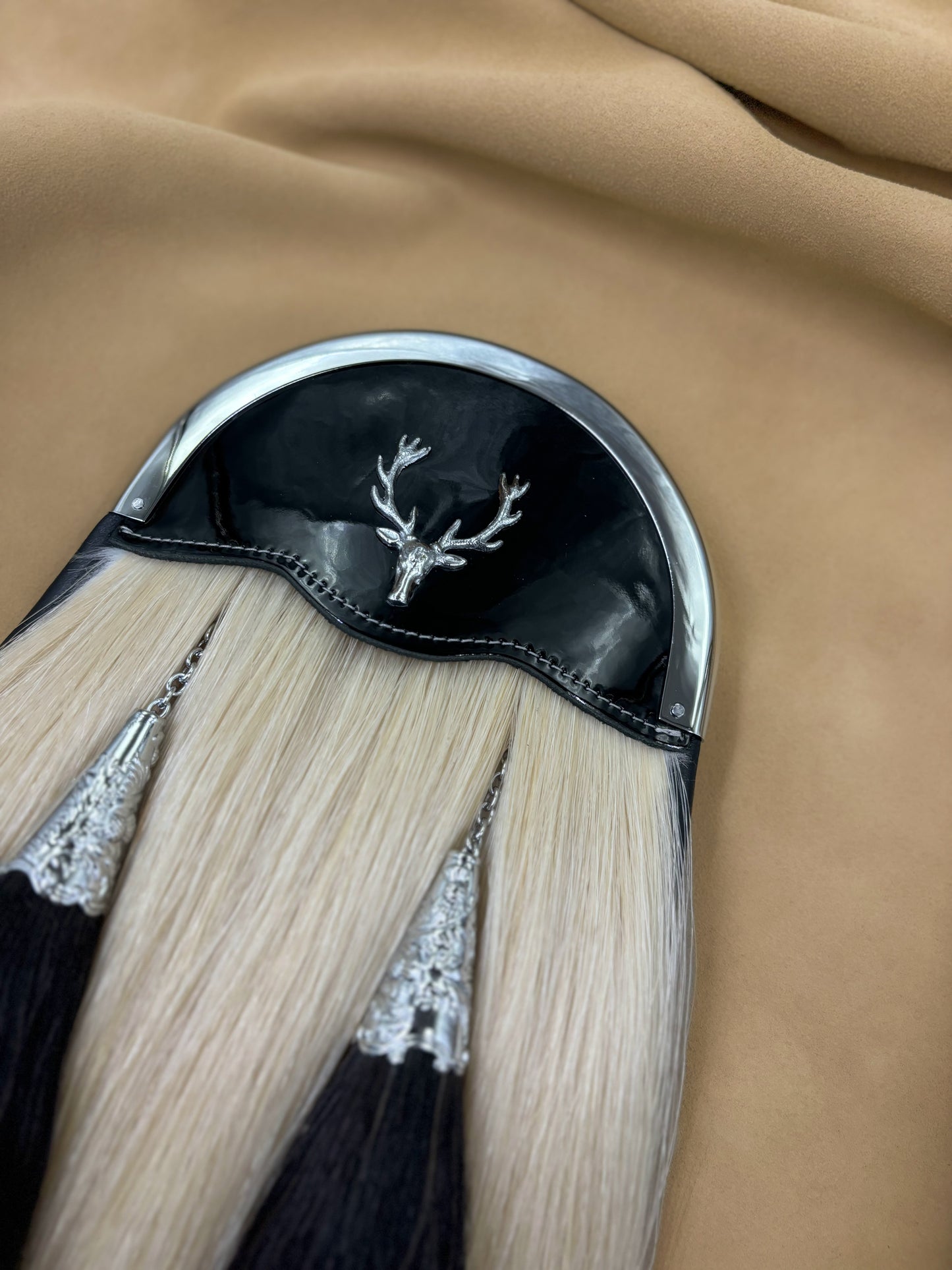 White horsehair sporran with black tassels and stag badge